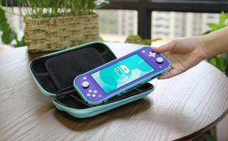 Best Switch Lite cases: photo of someone picking up a Switch Lite from a case