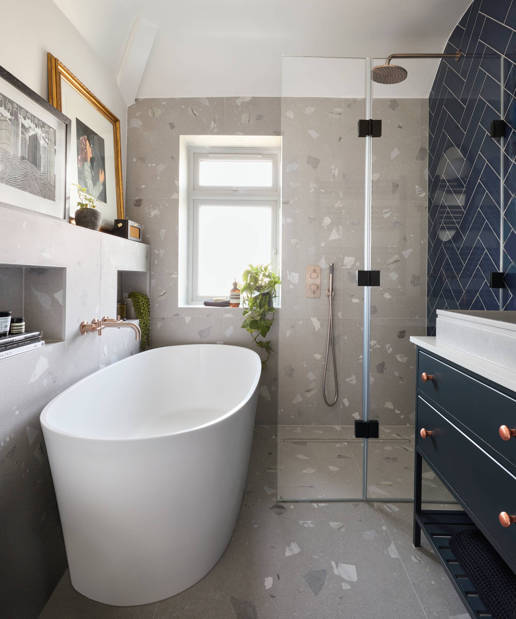 Modern freestanding bath and walk-in shower in bathroom with concrete and navy