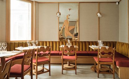 Interior of Cafe Compagnon with tables set with wine glasses and velvet chairs