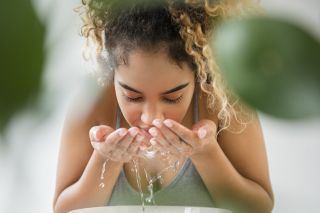 woman splashing water on face - stock photo