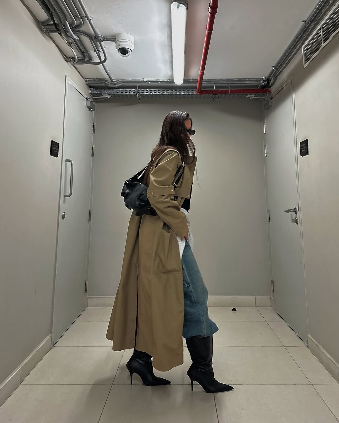 Woman wearing boots tucked into jeans trend fall 2025.