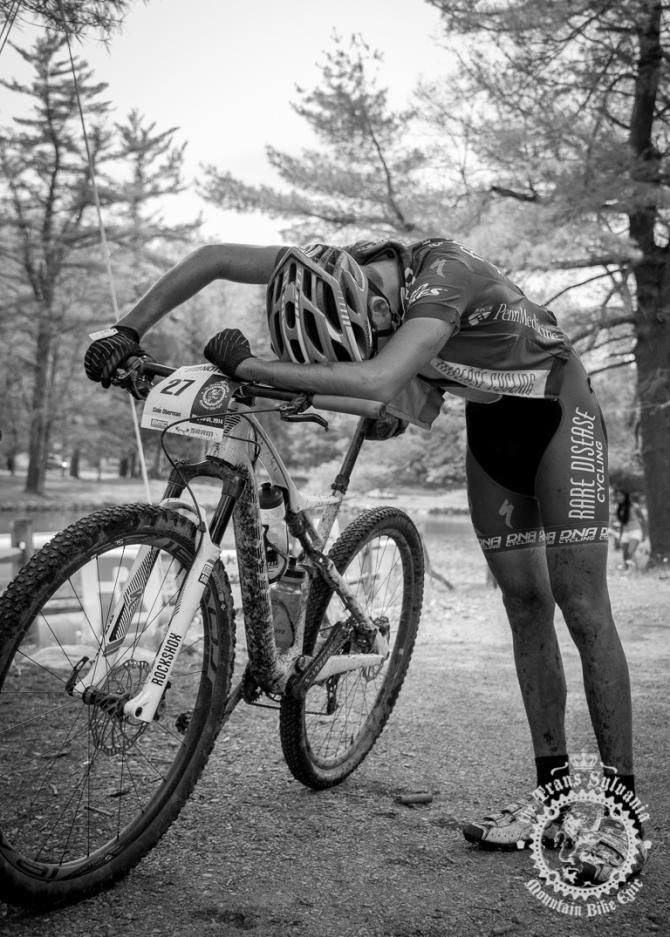 Cole Oberman (raredieseasecycling.org) falls on t op of his bike after passing the finish line