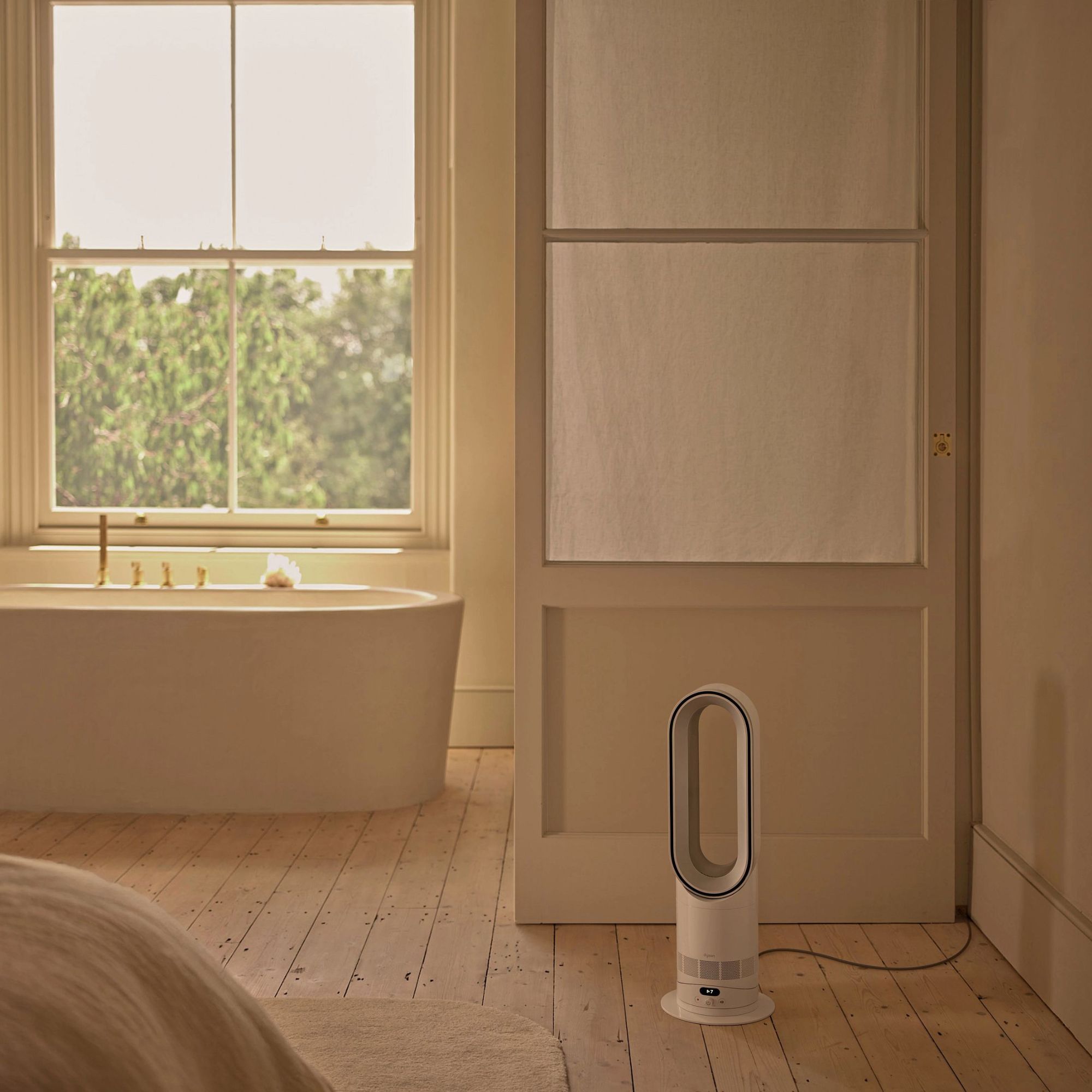 Dyson Hot+Cool HF1 Fan Heater on the floor in a bathroom with wooden floors and a freestanding tub