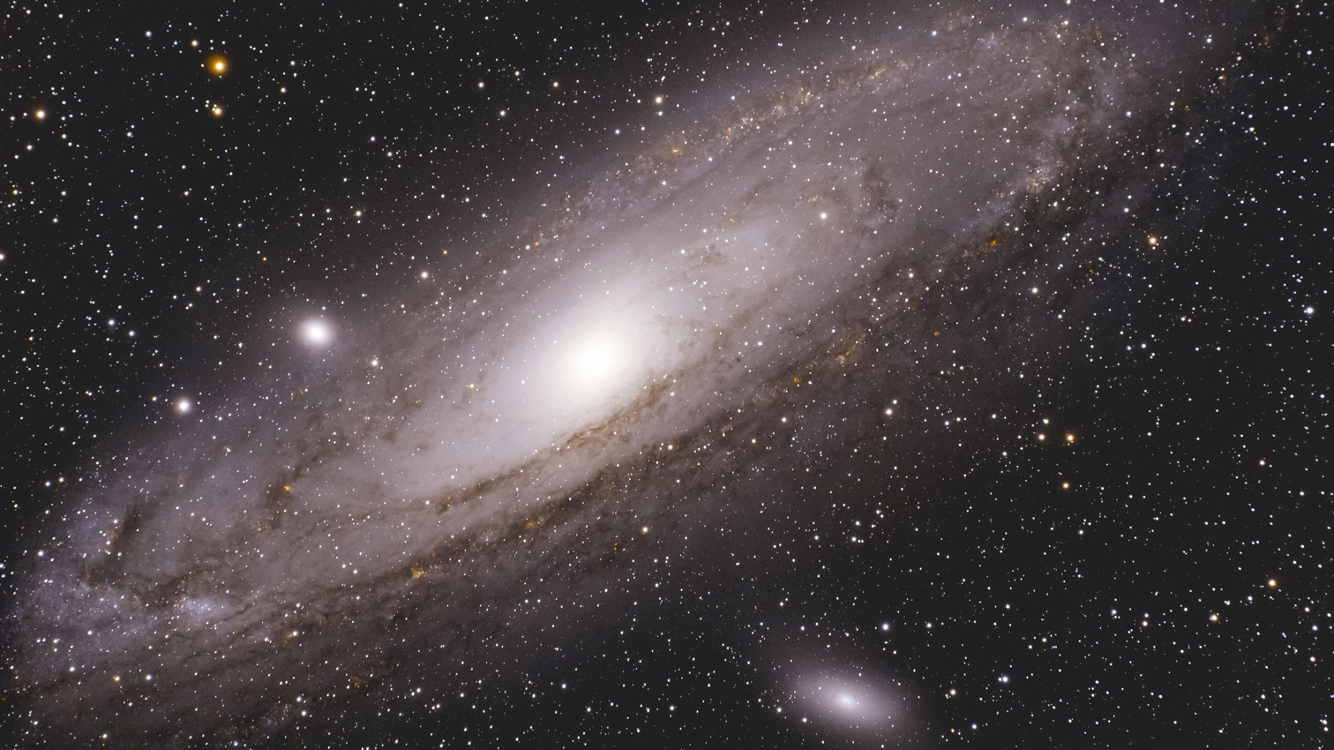 Centered amongst a field of stars is the Andromeda Galaxy which is a massive, brilliant, glowing white core that fades into expansive, oval-shaped spiral arms.