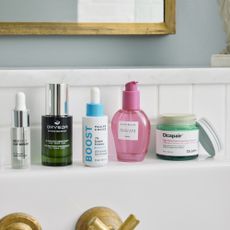 multiple skincare products on bathroom shelf