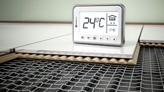 Underfloor heating cross section with temperature thermostat on tiled floor