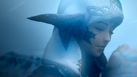 An au ra from Final Fantasy 14's evercold trailer kneels in the snow, praying as icy winds whip past her.