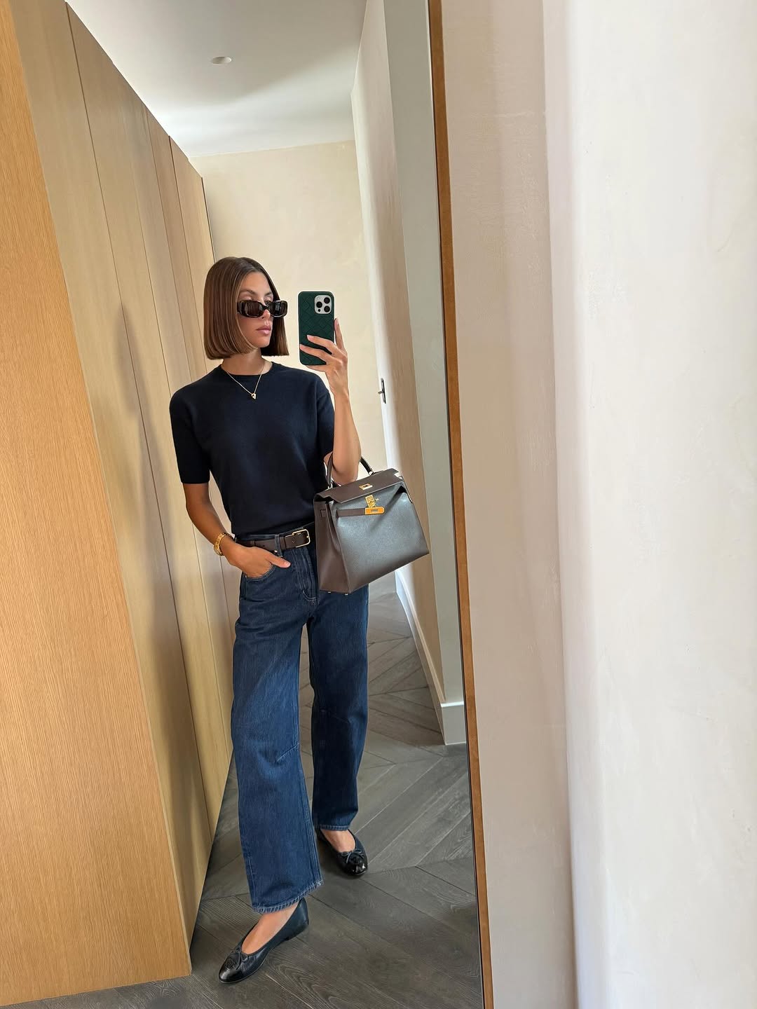 Woman wearing dark wash bootcut jeans fall 2025.