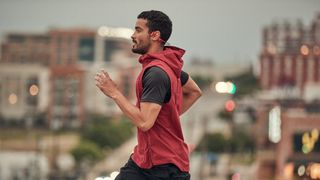 Man running in Shokz open-ear bone-conduction running headphones
