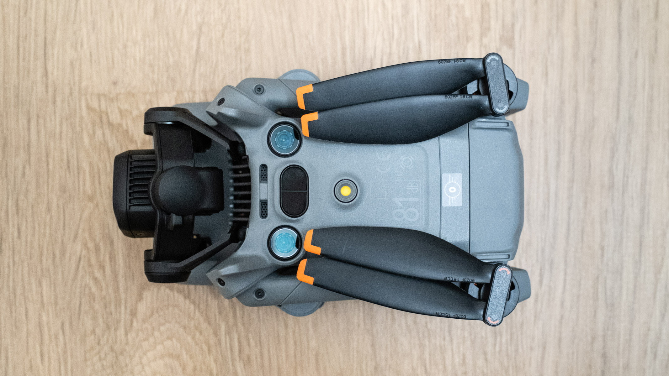 DJI Mini 5 Pro bottom view on a wooden floor
