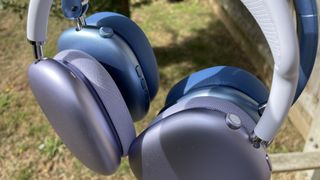 Wentronic YO1 (AirPods Max dupe) headphones in blue with AirPods Max nearby to compare and contrast their looks, outside on a sunny day