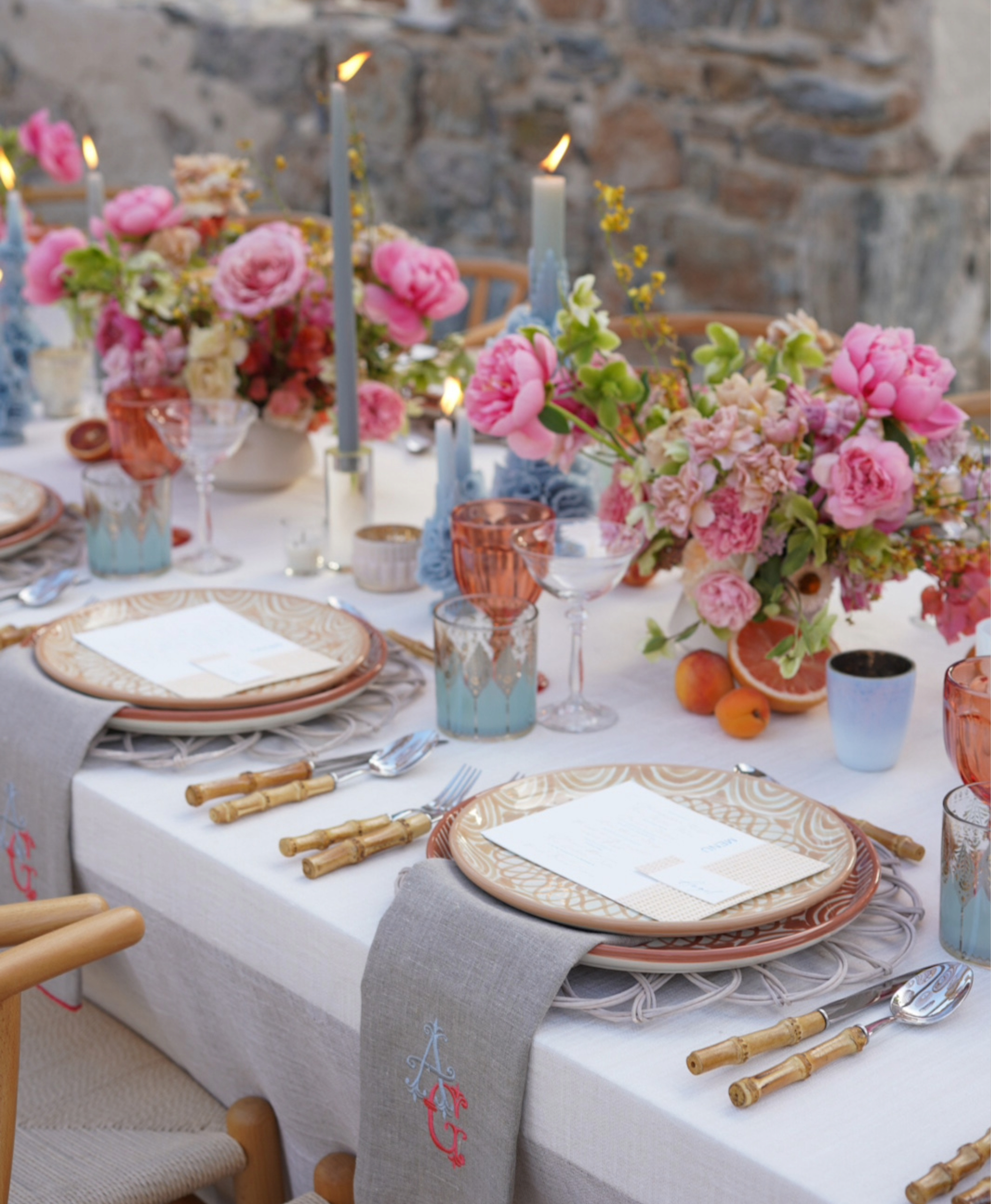 Table set with pink flowers blue candles and bamboo flatware