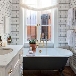 bathroom with white bathtub and potted plant