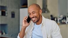 Happy entrepreneur working from home having a pleasant phone call 