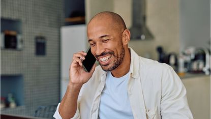 Happy entrepreneur working from home having a pleasant phone call 