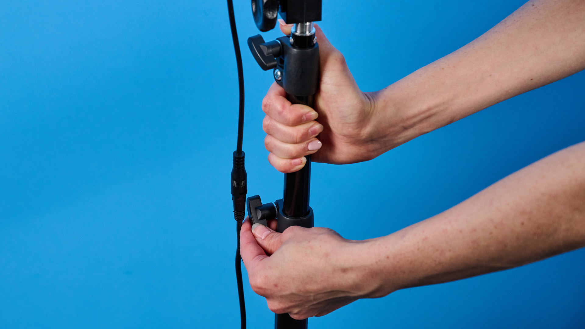 Neewer RL-18 ring light photographed in front of a blue background.