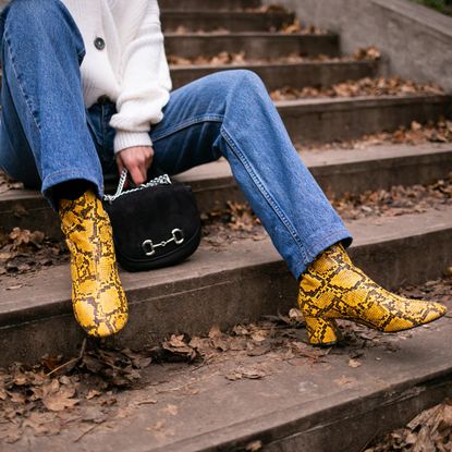 woman sitting on steps wearing yellow patterned boots