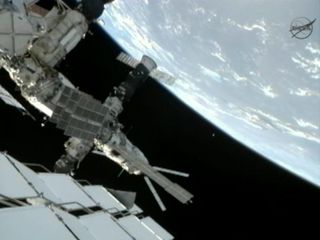 Photo of small satellite drifting from space station.