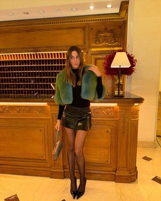 @camillecharriere wearing Jimmy Choo heels with a mini skirt and faux fur