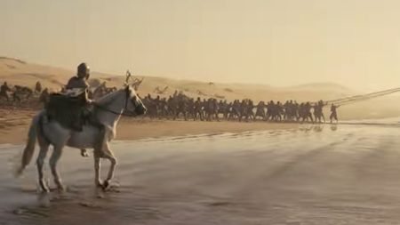 A man on a horse on a beach with an army ahead of him in The Odyssey