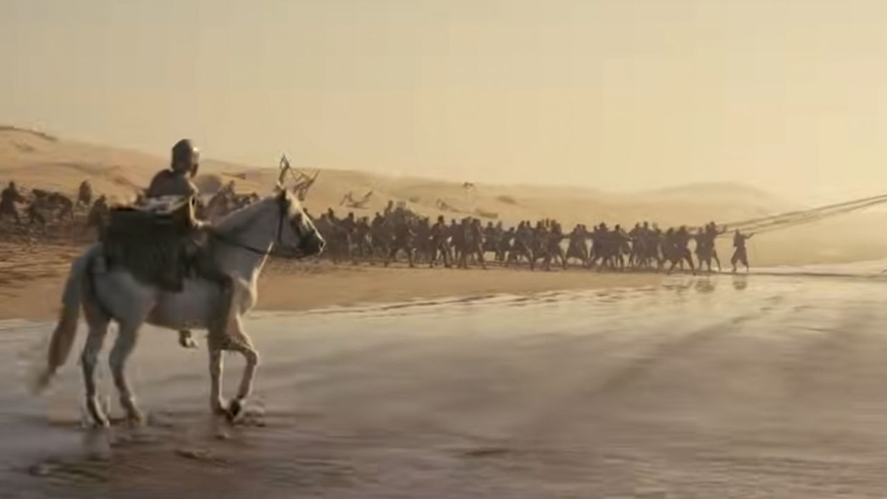 A man on a horse on a beach with an army ahead of him in The Odyssey