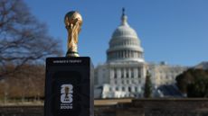 The FIFA World Cup trophy is seen in front of the United States Capitol building. 