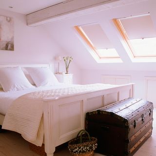 attic white bedroom with bed and flower vase