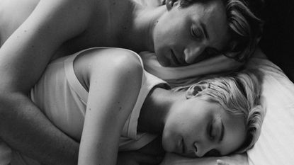 Couple spooning in bed, sleep & wellness tips