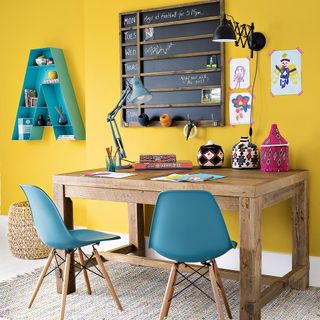 yellow kids room with shared wooden desk