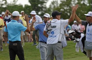 Hardy and Riley high five with their caddies after holing the putt on the 18th hole