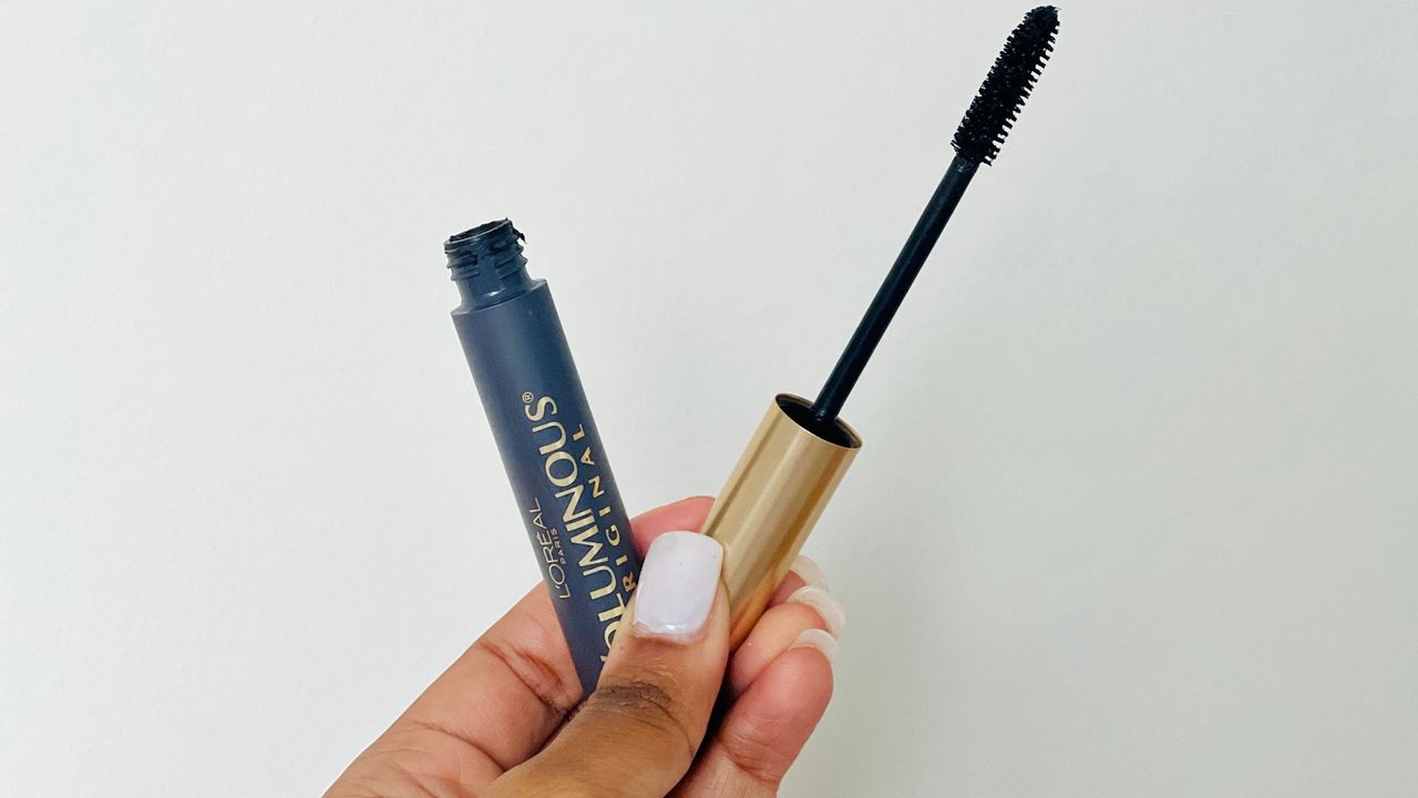 A person holding an opened L'Oreal Voluminous Original mascara for the best L'Oreal mascara.