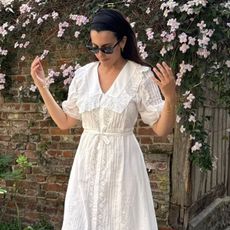 Woman wears white lace dress from Rixo