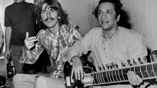 Hollywood: Beatle George Harrison, (L), listens as Ravi Shanker of India plays the sitar, 8/3, a 25-stringed guitar-like instrument. Harrison said he is studying the sitar under Shanker, because Indian music makes God come through in a spiritual way." Harrison is vacationing in Southern California.