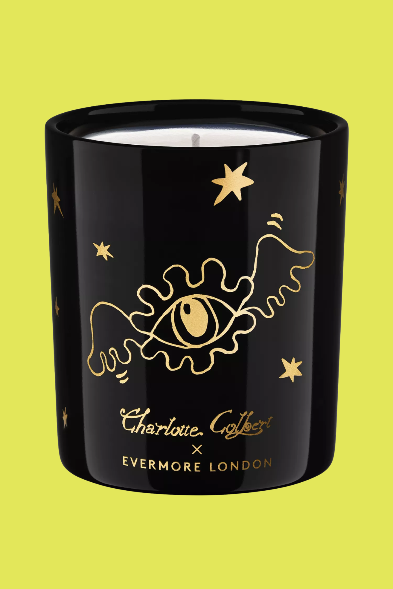 A glass candle with gold doodles on the front