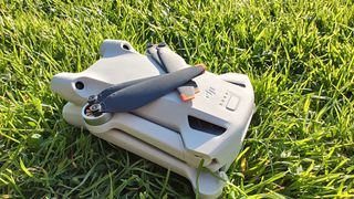 DJI Mini 3 Pro har vingerne foldet sammen og ligger i græsset