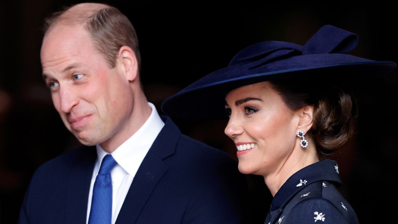 Prince William smirks while wearing a blue tie and suit and Kate Middleton smiles in a navy dress and matching hat at the 2023 Commonwealth Day Service at Westminster Abbey on March 13, 2023