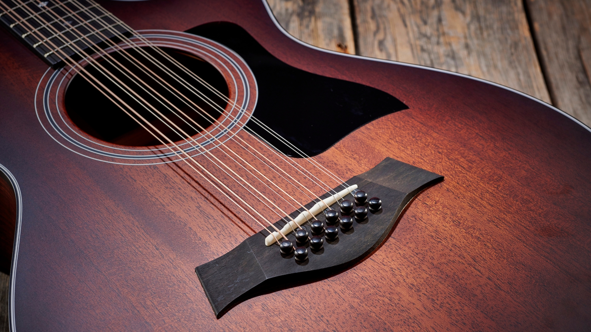 A Taylor 362ce 12-string acoustic guitar lying on a wooden floor