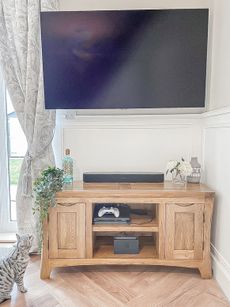 Wall mounted TV on wooden cabinet with all wires concealed