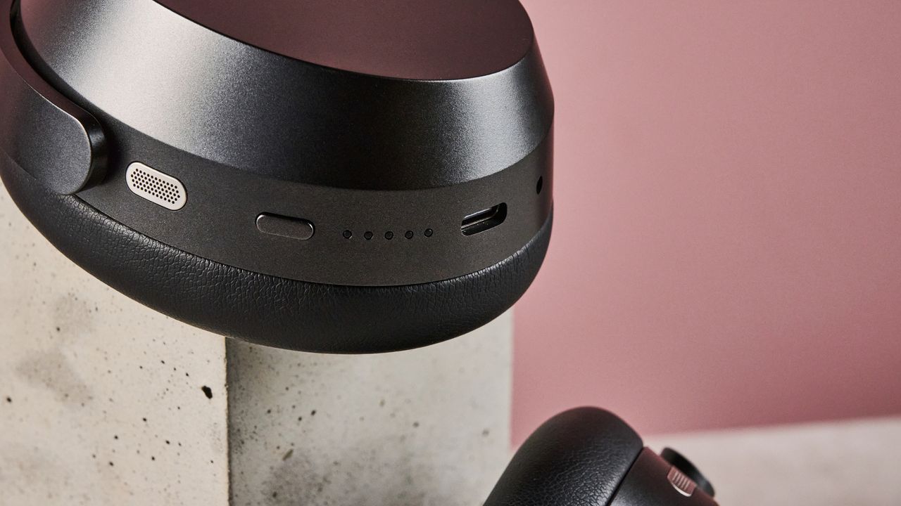 A closeup of the microphone, button and USB-C port on the bottom of the Sennheiser Momentum 5's right earcup.