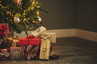 A Christmas tree with wrapped gifts under it