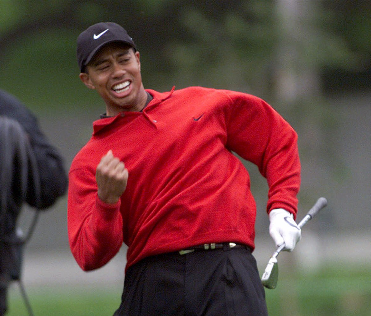 Tiger Woods celebrates after holing out his approach shot