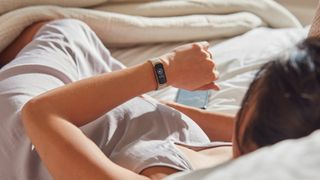 FitBit Luxe being worn by woman waking up in bed