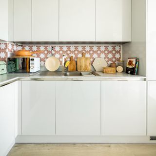 A white kitchen with patterned tiled backsplash