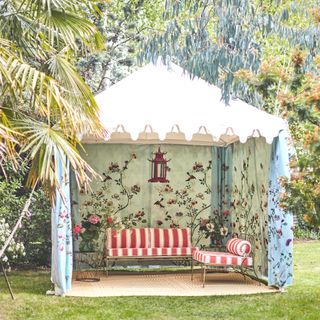 decorative tent with red striped sofa and chair in garden