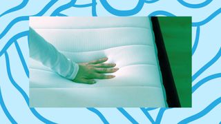 A woman's hand feels the squidgy surface of a memory foam mattress.