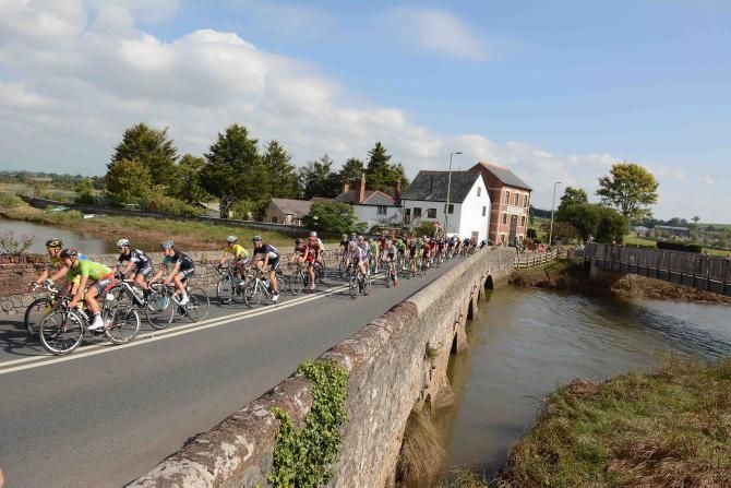 The peloton crosses the Exe river