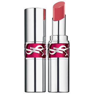 a tube of YSL Candy Glaze lip gloss in front of a plain backdrop