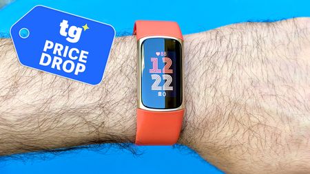 Close-up of the Fitbit Charge 6 on an orange strap next to a Tom's Guide deals badge