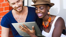 A man and a woman smilingly using the Dell Inspiron 14 2-in-1 unfolded 