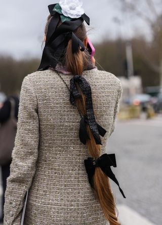 A woman in Paris with an elaborate hair ribbon and a tailored jacket